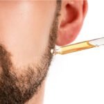 Homem aplicando óleo na barba para hidratação e crescimento saudável em 7 dias