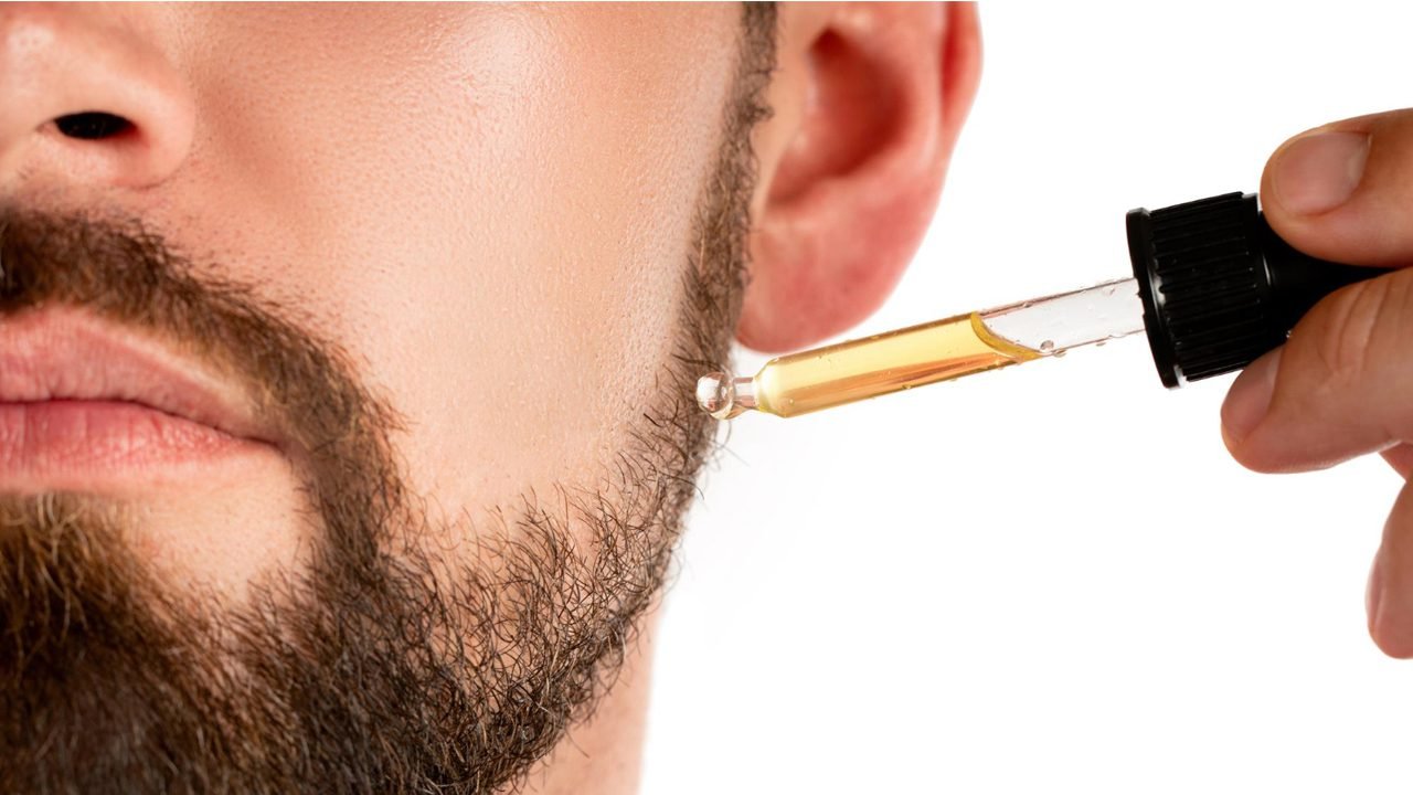 Homem aplicando óleo na barba para hidratação e crescimento saudável em 7 dias
