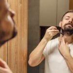 homem fazendo rotina de cuidados com a barba usando pente e produtos